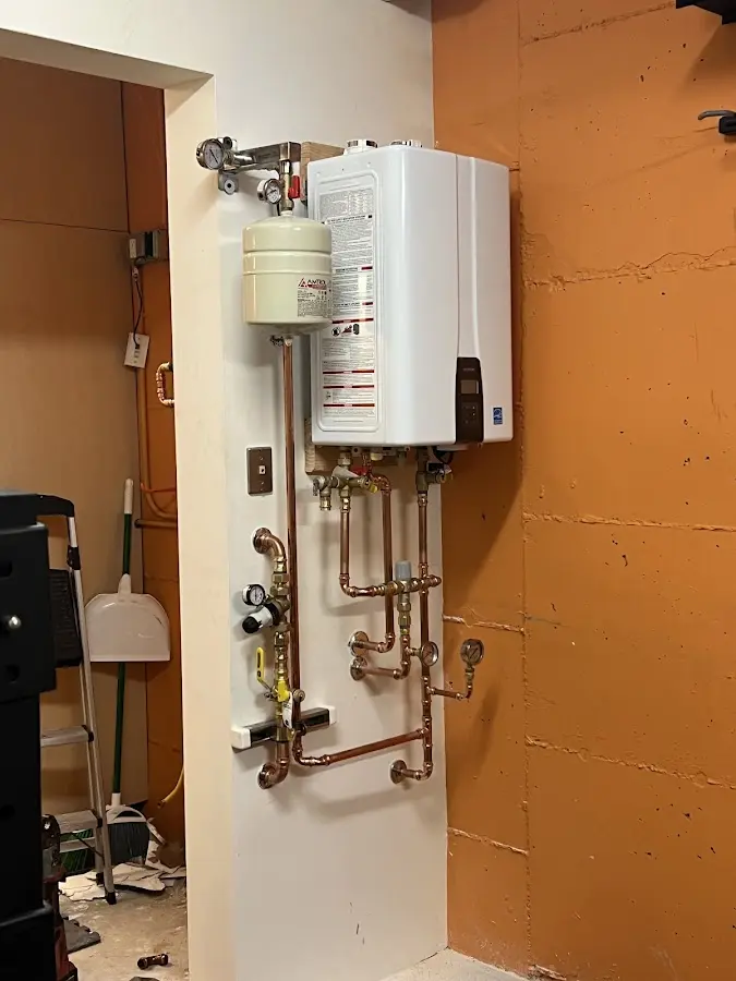 Plumbing technician inspecting water heater connections in Belton